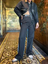 Pantalón negro de corte recto con detalle de franja celeste en el lateral.