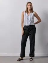 Pantalón negro de lino con pretina ancha y lazo de ajuste.