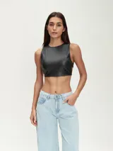 Top corto negro de cuero sintético, con cuello redondo y sin mangas.