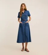 Vestido midi de jean con cuello camisero, manga corta y cierre frontal con botones. Cuenta con bolsillos frontales con solapa en el pecho, bolsillos laterales en la falda y cinturón ajustable con hebilla redonda carey.
