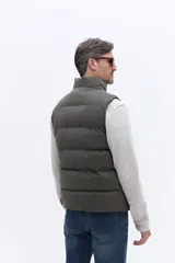 Chaleco puffer de nylon con diseño matelaseado, cuello alto y cierre frontal. Cuenta con bolsillos laterales y un pequeño parche con logo en el pecho.