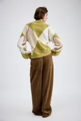Pantalón de tiro medio confeccionado en tejido de pana, con diseño de pierna ancha, bolsillos delanteros y traseros, y cierre frontal con cremallera y botón.