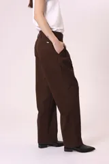 Pantalón de vestir marrón oscuro, de corte recto y holgado, con pinzas frontales y tiro alto.