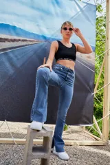 Pantalón de jean azul de tiro alto, corte semi oxford con botamanga ancha y abierta, y ruedo al corte.