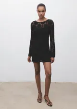 Vestido corto de crochet color negro, con cuello redondo, manga larga acampanada, espalda abierta con cierre de lazo y forro interior.