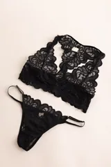 Soutien tipo bralette negro de encaje con diseño floral, espalda estilo nadador y elástico en el bajo busto para sujeción.