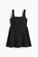 Vestido corto negro con estampado de lunares blancos, escote cuadrado, breteles anchos, cuerpo entallado y falda evasé con vuelo.