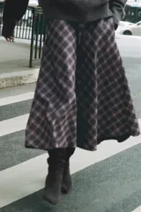 Falda midi de tiro alto ZARA Woman Collection, con diseño evasé y estampado de cuadros en tonos oscuros con líneas rojas y blancas. Cuenta con cierre lateral con cremallera oculta.
