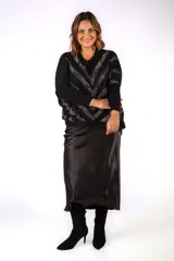 Sweater negro de punto con diseño de líneas en zigzag decoradas con strass brillante. Presenta cuello en V, mangas largas con puños ajustados y un corte holgado tipo murciélago.