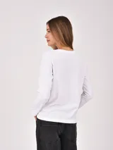 Remera básica blanca de manga larga y cuello redondo.
