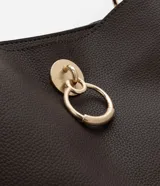 Bolso mediano color marrón oscuro, con doble asa corta y correa larga extraíble. Presenta textura símil cuero y detalle de aro dorado en el frente.