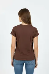 Remera de algodón color beige, de manga corta con vuelta, cuello redondo y corte holgado. Cuenta con un estampado frontal con la inscripción "Manhattan New York East Coast" en tonos celestes.