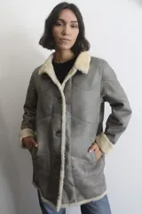 Campera de napalán de cuero genuino con interior de piel sintética, diseño con capucha desmontable, cierre frontal con botones y bolsillos laterales.