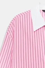 Camisa de rayas rosas y negras, con cuello solapa y puños anchos en color blanco. Presenta mangas largas, bajo asimétrico y cierre frontal con botones.