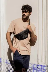 Riñonera gris con dos bolsillos con cierre y correa ajustable con hebilla.