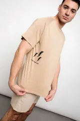 Remera color beige con estampa de tres rayos negros y la frase "Rock That Day".