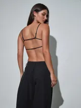 Top negro de tirantes finos con textura y apliques brillantes, escote redondo y diseño corto.