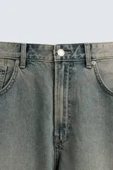 Jeans de denim de algodón, color azul oscuro con efecto lavado. Presentan un corte muy holgado (baggy fit) en toda la pierna y tiro medio. Tienen cinco bolsillos y cierre frontal con cremallera y botón.