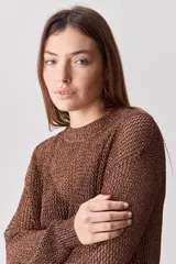 Sweater calado de punto negro, con cuello redondo y mangas largas, de diseño liviano ideal para superposiciones.