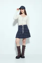 Top de tejido acanalado color negro, con escote en V y cierre frontal mediante cordones ajustables con ojales metálicos. Presenta mangas largas y un corte entallado al cuerpo.