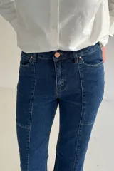 Jeans de denim color beige, de tiro alto y corte recto, con costuras verticales decorativas en el frente.