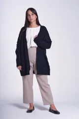 Cárdigan negro tejido con diseño de ochos, corte holgado y bolsillos frontales.