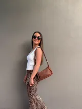 Cartera bandolera de cuero color marrón, con correa ajustable y bolsillo externo con cierre.