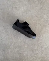 Zapatillas urbanas de cuero vacuno color negro, con suela alta y cordones.