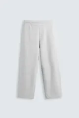 Pantalón jogger de corte relajado y pernera ancha, confeccionado en tejido de algodón con interior perchado. Cuenta con cintura elástica ajustable mediante cordón interior, bolsillos laterales y un bolsillo trasero de plastrón.