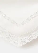 Top asimétrico de lino y viscosa color crudo, con tirantes finos tipo halter, escote diagonal y detalles de encaje en los bordes.