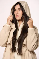 Campera tipo trench de nylon color negro, con capucha, cierre frontal y cordón ajustable en la cintura.