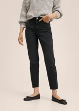 Jeans mom-fit de tiro alto color negro, confeccionados en denim elástico con diseño de cinco bolsillos y trabillas para cinturón.