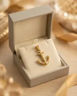 Dije en forma de ancla con baño de oro, de diseño náutico clásico.