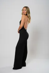 Mono negro de punto con escote halter o en V, con corte holgado y cinturón con argollas metálicas.