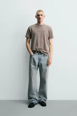Remera de punto de algodón color gris topo, con efecto lavado, cuello redondo y manga corta. Cuenta con aplicación de parches con texto desgastado en el frente.