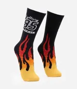Medias de caña larga con diseño inspirado en Rayo McQueen de Cars. Presentan un estampado de llamas en tonos rojos, naranjas y amarillos sobre una base negra, con el número 95 y el nombre del personaje bordados en la parte superior.