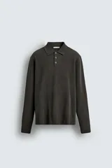 Polo de punto con textura, corte regular fit, cuello solapa con cierre frontal de tres botones, manga larga y acabados en rib.