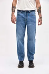 Jean de corte tapered, holgado en la cadera y levemente ajustado hacia los tobillos, con tiro medio y cierre frontal con botones.