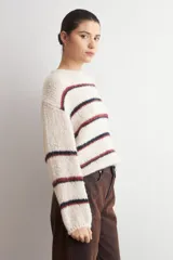 Sweater de tejido de punto grueso con diseño de rayas horizontales en tonos azul y rojo sobre base color natural, cuello redondo y mangas largas.