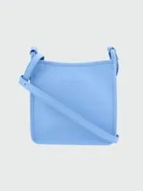 Bandolera pequeña de cuero granulado color celeste claro, de forma cuadrada, con correa ajustable delgada.