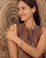 Brazalete rígido de diseño orgánico, compuesto por eslabones irregulares unidos entre sí, con acabado metálico brillante.