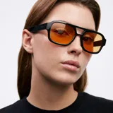 Lentes de sol de aviador oversize con montura negra y lentes color naranja. Protección UV400.