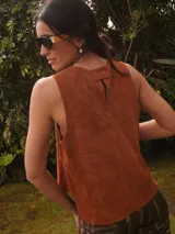 Chaleco de gamuza negro, sin mangas, con cuello redondo y diseño bordado de un sol en el pecho.