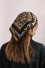 Pañuelo cuadrado con estampado combinado animal print de leopardo, cebra y lunares, en tonos marrón, negro, blanco y tostado con bordes en marrón oscuro.