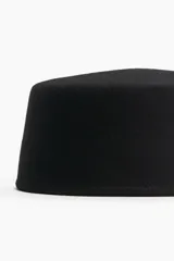 Sombrero tipo pillbox de lana afieltrada en color negro, con diseño minimalista y estructura rígida.