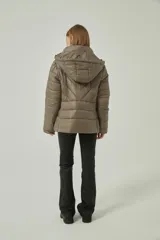 Campera puffer con capucha, color camel, confeccionada en poliéster con relleno acolchado, cierre frontal y diseño entallado.