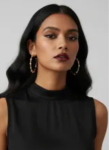 Aros de argolla metálicos en color dorado con incrustaciones de cristales de colores. Presentan un diseño elegante con acabado brillante y cierre independiente.