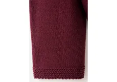 Sweater de punto color bordó, con cuello alto, mangas largas y diseño holgado.