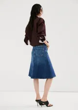 Falda midi evasé de denim azul con diseño de corte trapecio, tiro medio, trabillas y bolsillos.