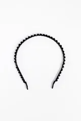 Vincha fina de color negro adornada con pequeños apliques de pedrería y cuentas facetadas a lo largo de toda su estructura.
